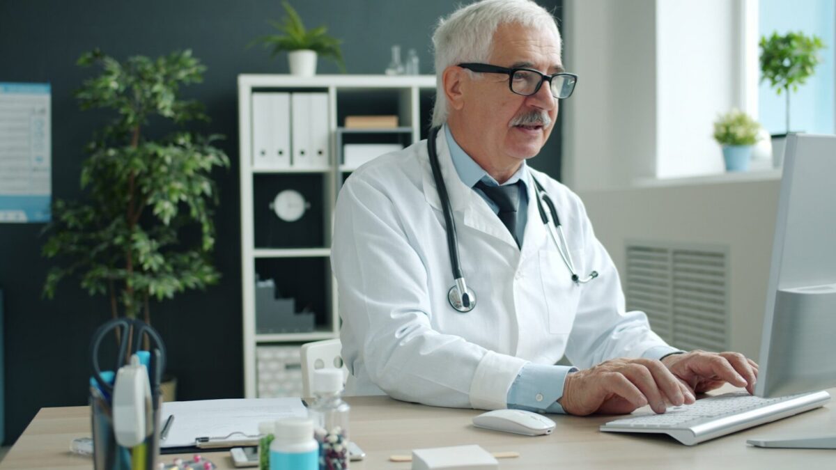Doctor typing on computer in office